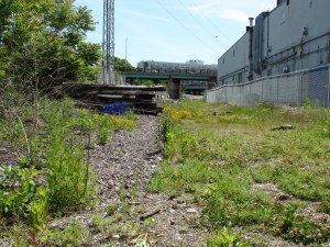 Gravel, grass, industrial buildings, abandoned materials.